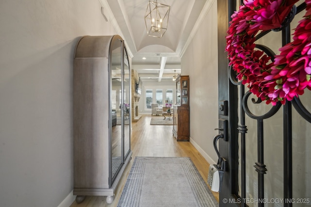 entrance foyer with light wood-style floors, beam ceiling, coffered ceiling, and baseboards