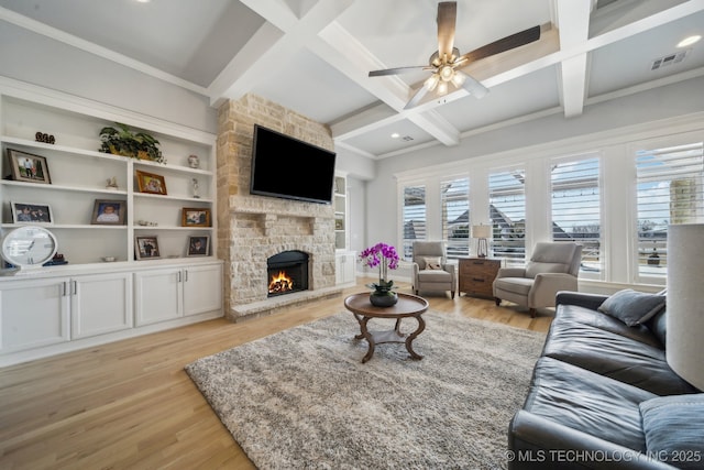 living room with a fireplace, visible vents, light wood-style floors, coffered ceiling, and beamed ceiling