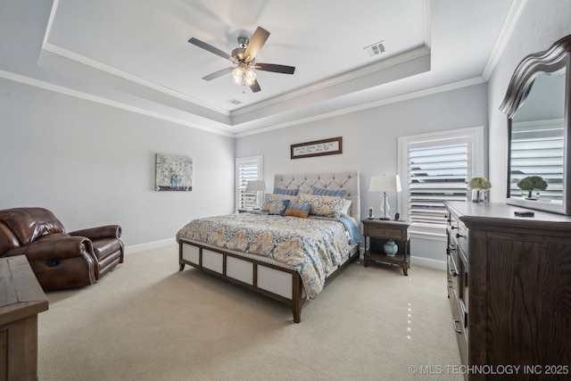 bedroom with light carpet, baseboards, visible vents, a tray ceiling, and crown molding