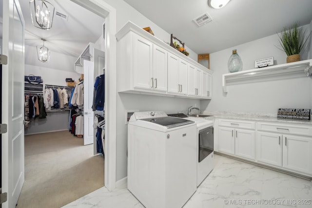 laundry room featuring marble finish floor, visible vents, cabinet space, washing machine and dryer, and a sink