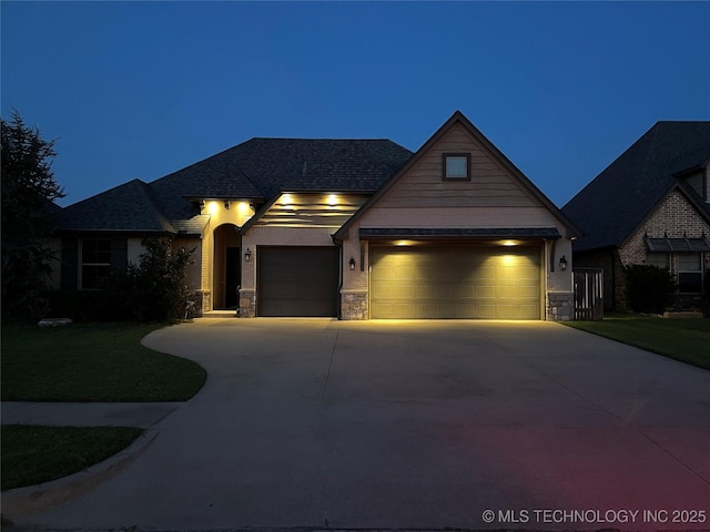 craftsman-style home with driveway, stone siding, and an attached garage