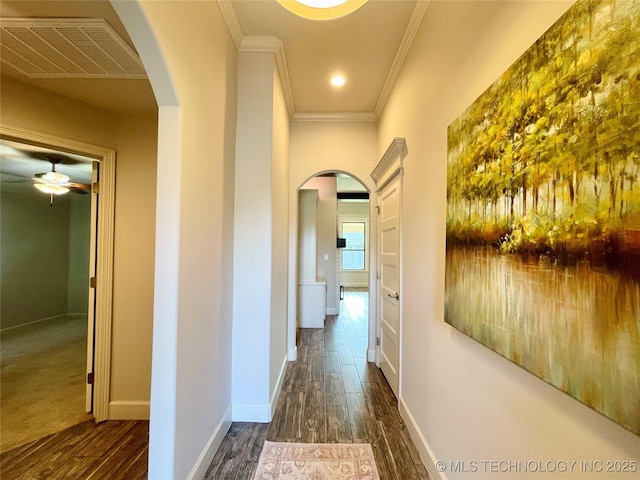 hallway featuring dark wood-style floors, arched walkways, and visible vents