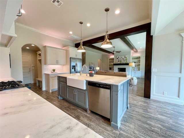 kitchen featuring light stone counters, arched walkways, stainless steel appliances, visible vents, and white cabinets