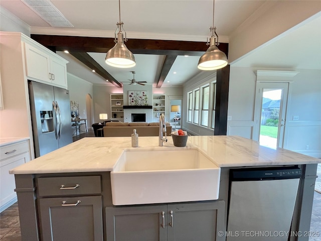 kitchen with stainless steel appliances, a sink, and an island with sink