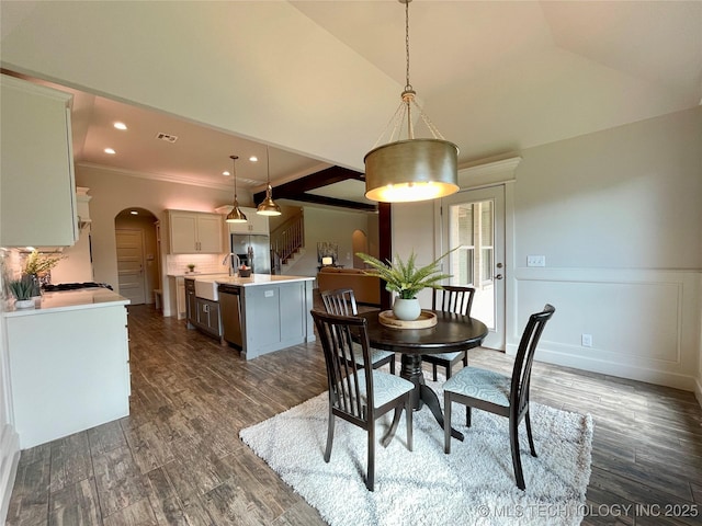 dining area featuring arched walkways, stairway, dark wood-type flooring, crown molding, and recessed lighting