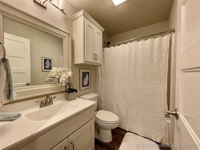 full bath featuring toilet, wood finished floors, and vanity