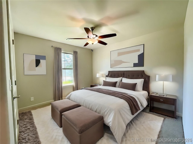 bedroom with light carpet, ceiling fan, and baseboards