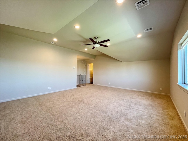 empty room featuring recessed lighting, visible vents, vaulted ceiling, and baseboards