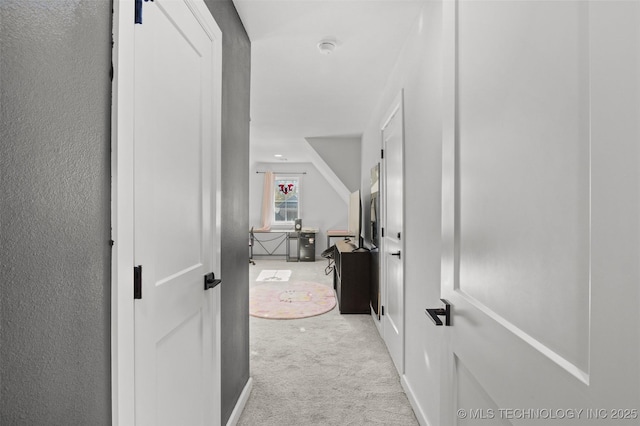 corridor featuring light carpet and vaulted ceiling