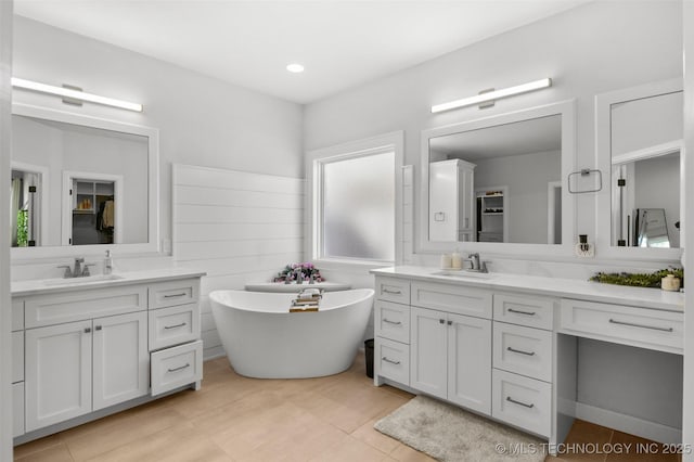 bathroom with two vanities, a sink, and a spacious closet