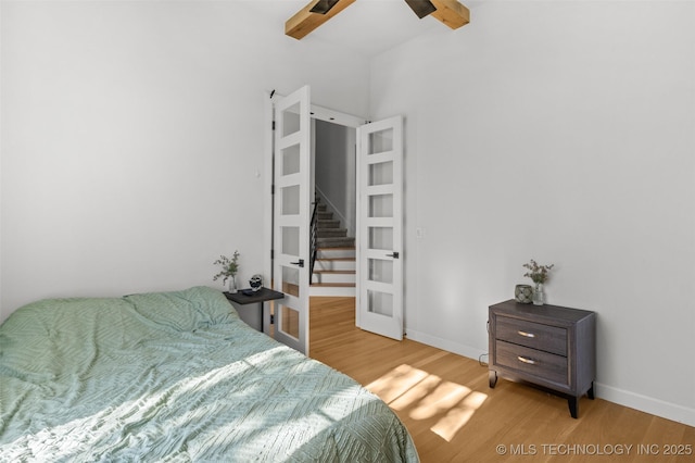 bedroom with light wood-style flooring, baseboards, and french doors