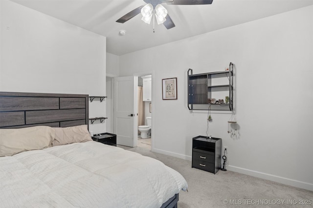 bedroom with light colored carpet, ceiling fan, ensuite bath, and baseboards