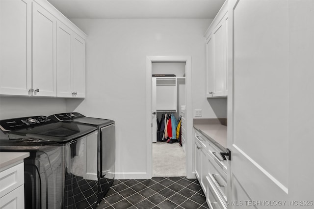 laundry room with dark colored carpet, cabinet space, separate washer and dryer, dark tile patterned floors, and baseboards