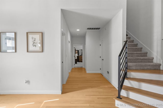 interior space featuring light wood-type flooring, stairway, and baseboards