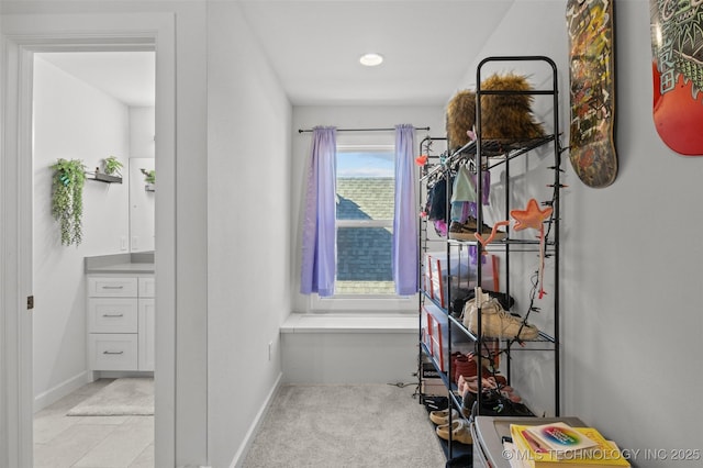 walk in closet with light colored carpet