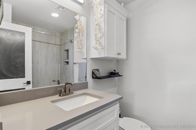 bathroom featuring toilet, visible vents, a shower, and vanity