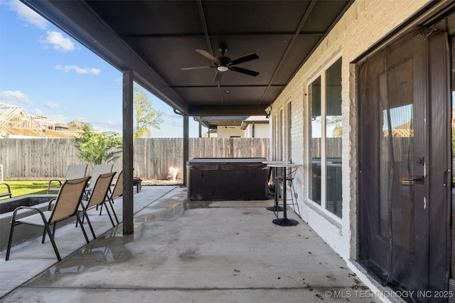 view of patio with a fenced backyard, a ceiling fan, and a hot tub