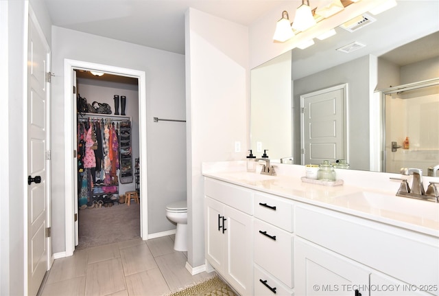 full bath featuring a walk in closet, double vanity, visible vents, a sink, and a shower stall