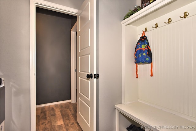 mudroom featuring baseboards and dark wood-type flooring