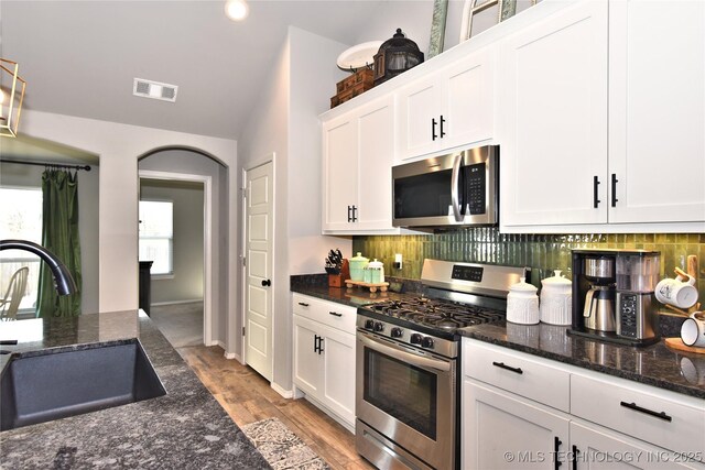 kitchen with visible vents, appliances with stainless steel finishes, white cabinets, and a sink