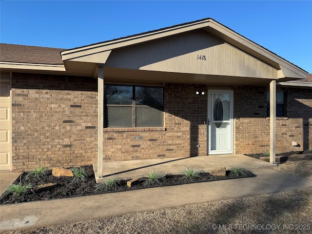 doorway to property with brick siding