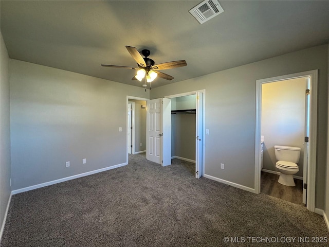 unfurnished bedroom featuring a closet, dark carpet, visible vents, and baseboards