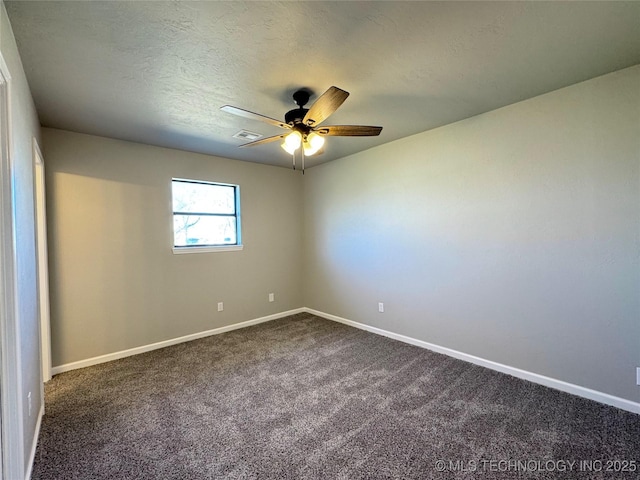 unfurnished room with ceiling fan, dark colored carpet, visible vents, and baseboards