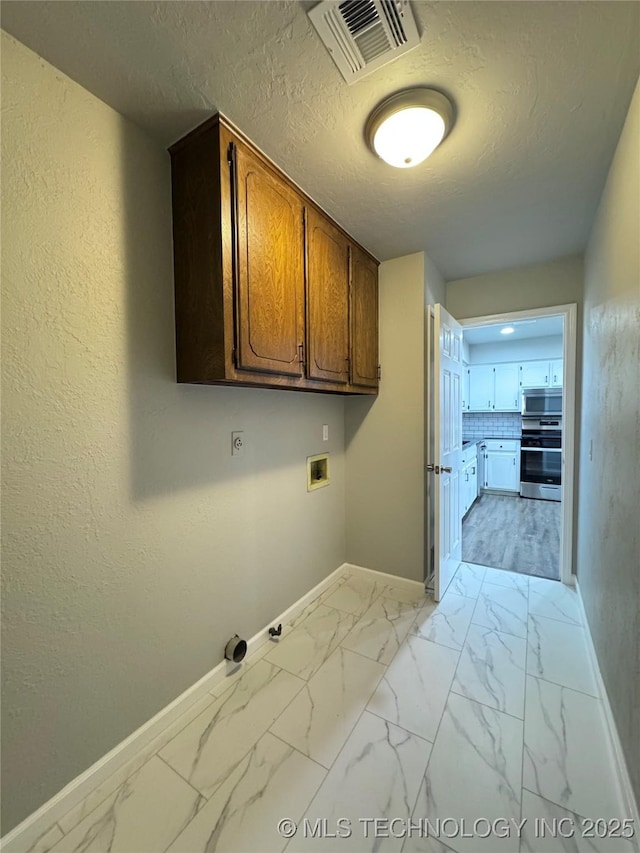 laundry area with washer hookup, marble finish floor, visible vents, and cabinet space