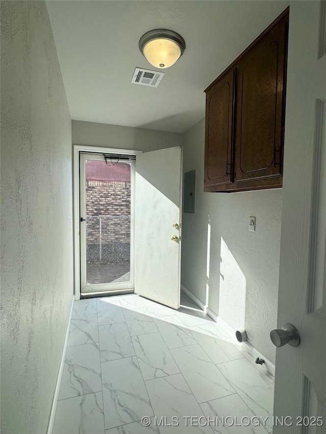 laundry area featuring a textured wall, visible vents, baseboards, marble finish floor, and electric panel