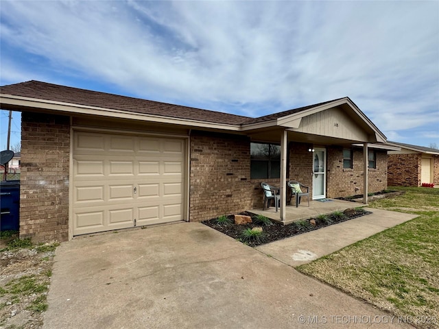 ranch-style house featuring a garage, brick siding, concrete driveway, and a front yard