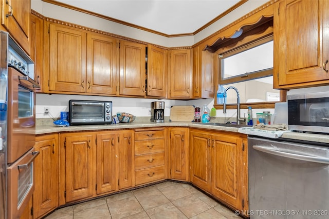 kitchen featuring a toaster, stainless steel appliances, a sink, light countertops, and brown cabinets