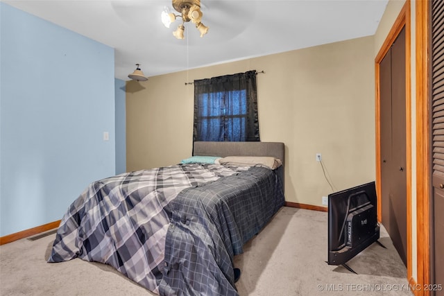 bedroom with baseboards, a closet, heating unit, and light colored carpet