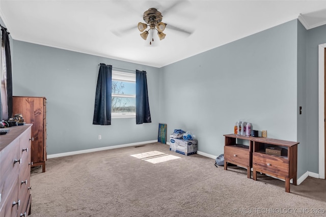 misc room with carpet, baseboards, ceiling fan, and crown molding