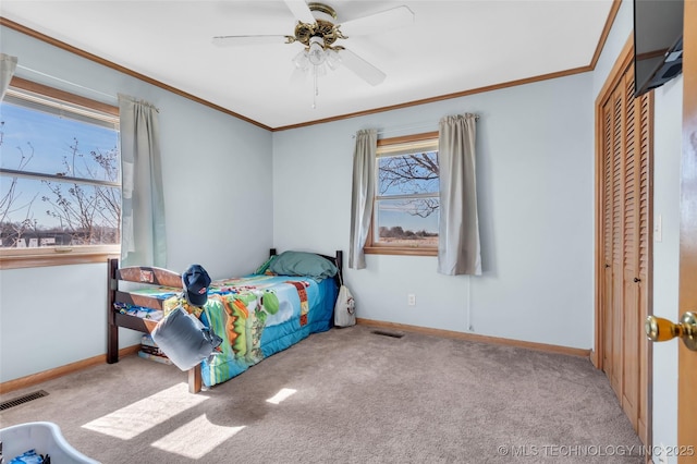 carpeted bedroom with baseboards, visible vents, and crown molding