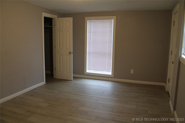 unfurnished room with wood finished floors and baseboards