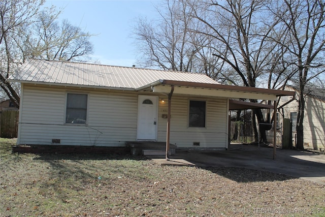 view of front facade with crawl space, driveway, metal roof, and a carport