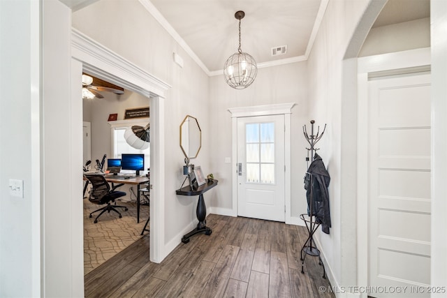 foyer entrance featuring arched walkways, wood finished floors, visible vents, baseboards, and ornamental molding