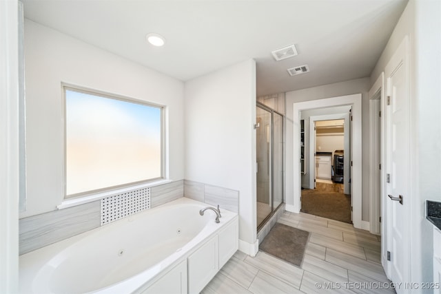 bathroom with a jetted tub, a stall shower, and visible vents