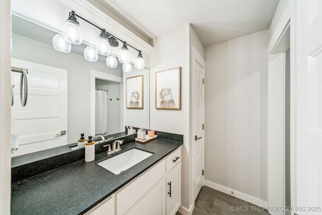 full bathroom featuring vanity and baseboards