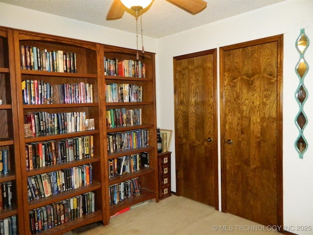 interior space with ceiling fan, carpet floors, and a textured ceiling