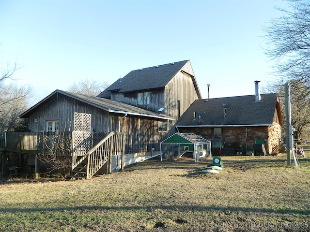 back of house with stone siding, a yard, stairway, and a wooden deck