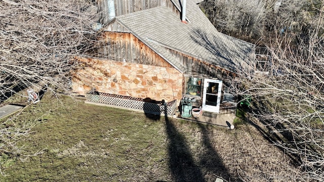 view of home's exterior featuring stone siding and a yard