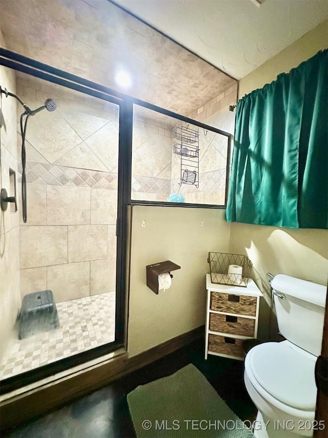 bathroom featuring a stall shower and toilet