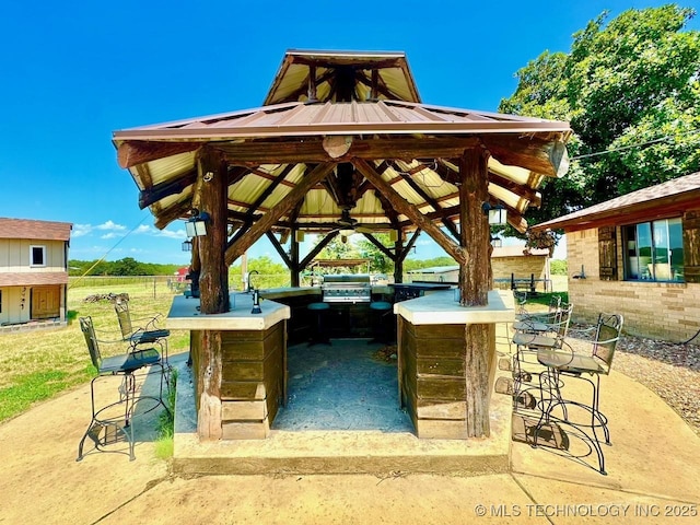 view of property's community with outdoor dry bar, a patio area, and an outdoor kitchen