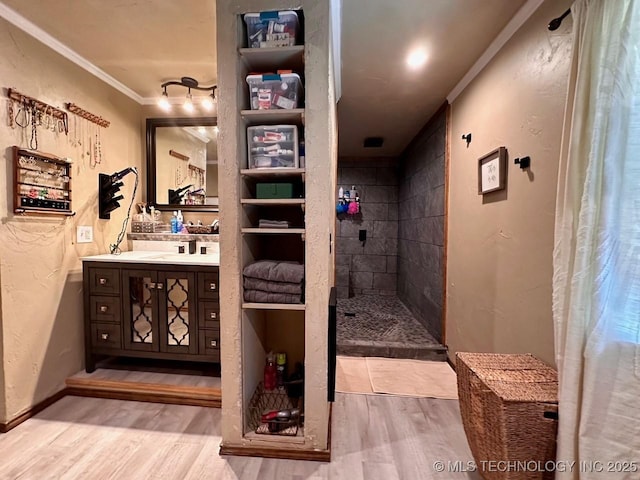 full bathroom with vanity, walk in shower, crown molding, and wood finished floors