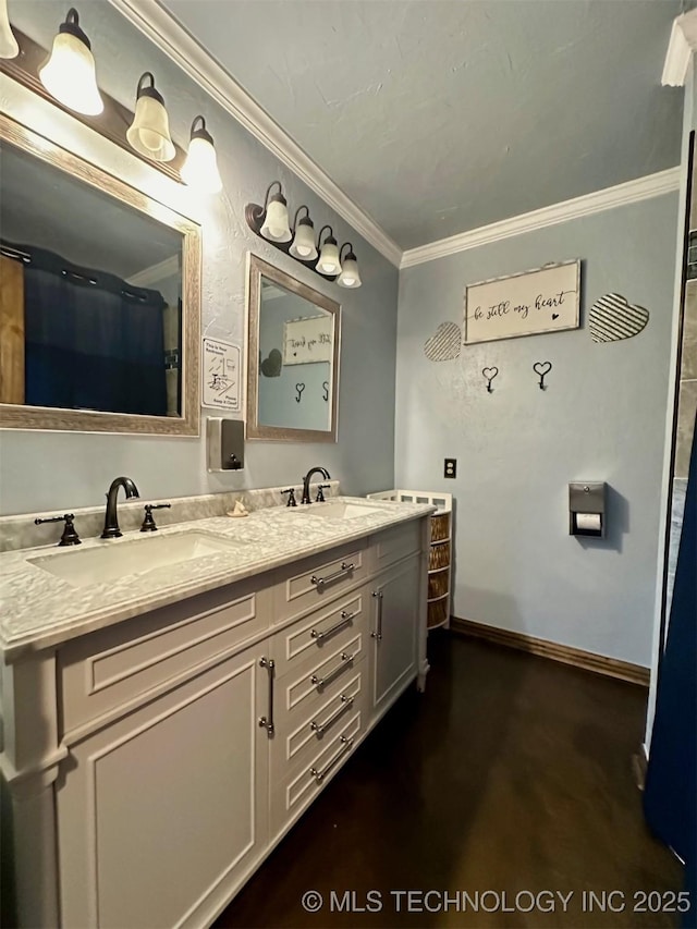 bathroom with double vanity, baseboards, ornamental molding, and a sink