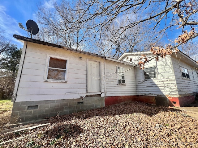 view of front of home with cooling unit and crawl space