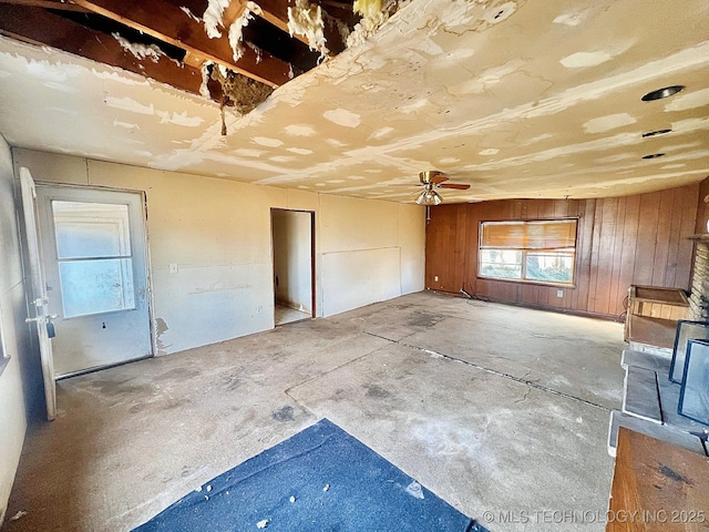 interior space featuring unfinished concrete flooring and wooden walls