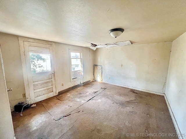 entryway with cooling unit, baseboards, and a textured ceiling