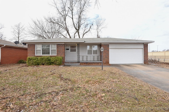 single story home with an attached garage, driveway, a front yard, and brick siding